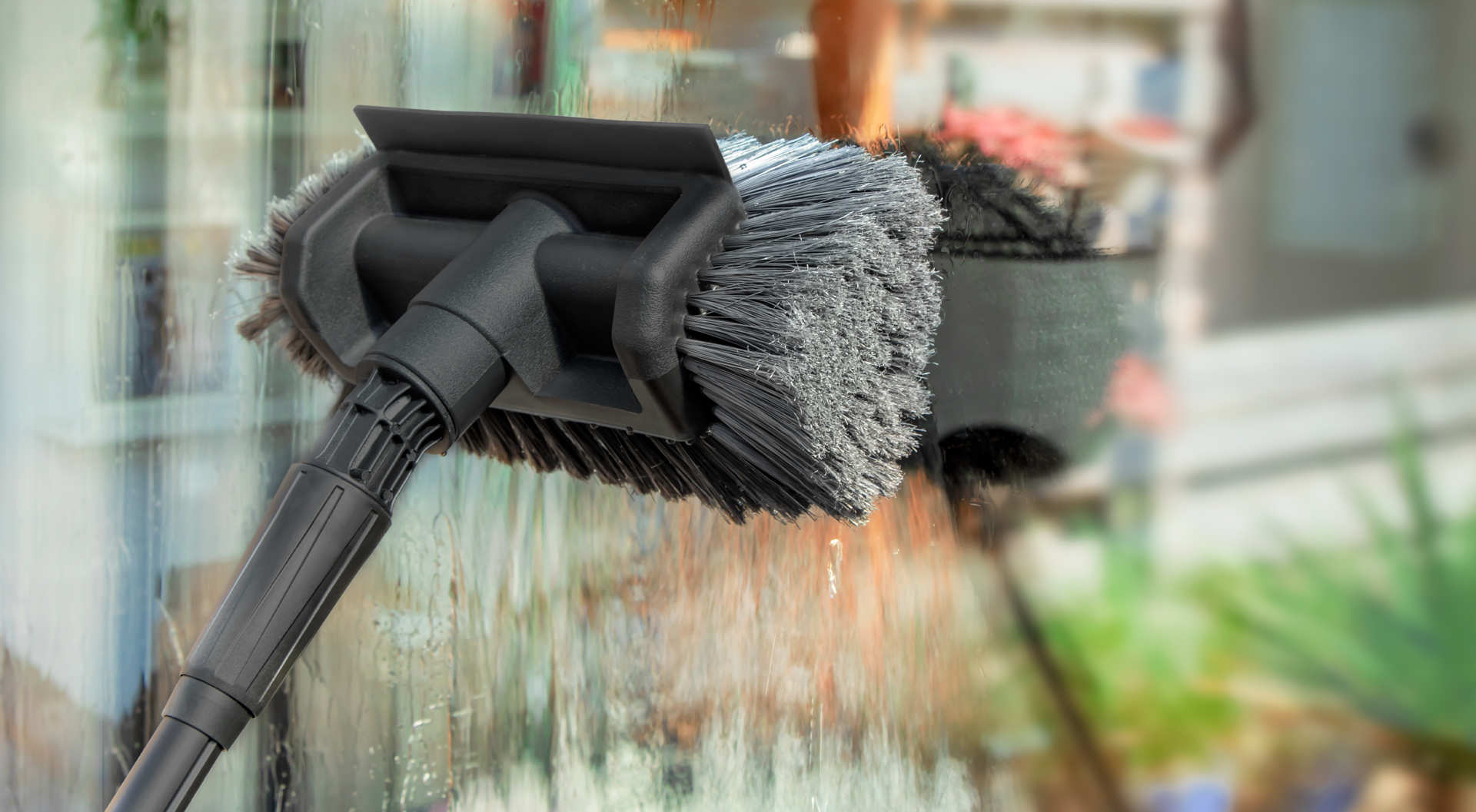 Rengøring af vinduer med en VONROC vaskebørste.